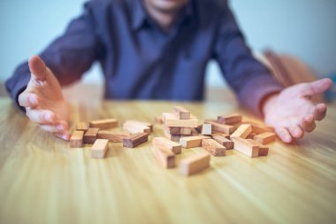 Ellerin tahta blok kule oyunu oynadığı iş stratejisi kavramı risk ve istikrarı sembolize ediyor. Risk yönetimi planlanıyor.