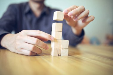 Stratejik olarak tahta blokları bir masanın üzerine yerleştirmek, ilerici başarı ve büyüme anlamına gelir..