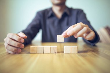 Stratejik olarak tahta blokları bir masanın üzerine yerleştirmek, ilerici başarı ve büyüme anlamına gelir..