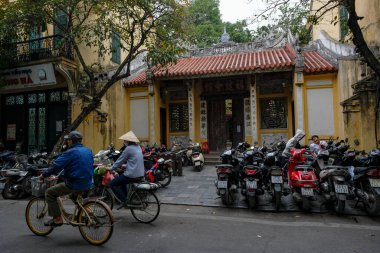 Hanoi, Vietnam - 9 Aralık 2022: Vietnam 'daki Hanoi Eski Mahallesi' nde bisiklet süren iki kişi.