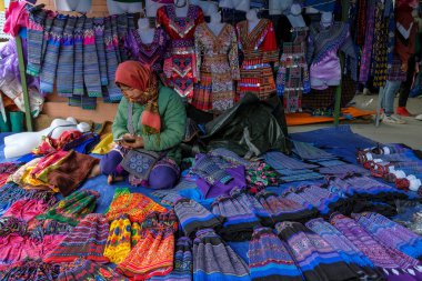 Can Cau, Vietnam - 17 Aralık 2022: Lao Cai, Vietnam 'daki Can Cau pazarında bir giyim satıcısı.