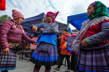 Bac Ha, Vietnam - 18 Aralık 2022: Vietnam 'daki Bac Ha pazarında geleneksel kıyafet satan bir kadın.