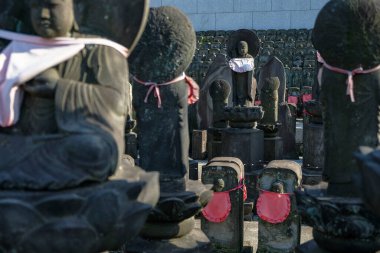 Tokyo, Japonya - 3 Mart 2023: Japonya 'daki Ueno Park' ta bulunan Jomyoin Tapınağı 'nda çocukların ve yolcuların koruyucu tanrısı Jizo' nun taş heykelleri.