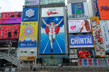 Osaka, Japonya - 21 Mart 2023: Dotonbori, Osaka, Japonya 'daki ünlü Glico Man' in önünde fotoğraf çeken turistler.