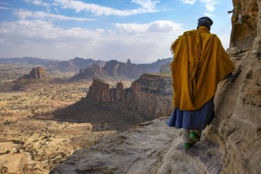 Megab, Ethiopia - January 9, 2018: A priest outside Daniel Korkor Church in Gheralta Mountains, Tigray, Ethiopia. clipart