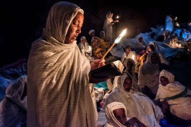 Lalibela, Etiyopya - 7 Ocak 2018: Pilgrimler, Biete Medhane Alem 'in (Dünya Kurtarıcısı Evi) önünde gece yanan mumlarla dua ediyorlar. Ocak ayının ilk günlerinde, binlerce Etiyopyalı Ortodoks Hıristiyan hacı