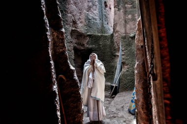 Lalibela, Etiyopya - 7 Ocak 2018: Biete Denagel (Bakireler Evi) girişinde dua eden bir kadın. Ocak ayının ilk günlerinde binlerce Etiyopyalı Ortodoks Hıristiyan hacı Etiyopya 'daki Lalibela şehrine gider..