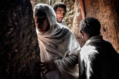 Lalibela, Etiyopya - 7 Ocak 2018: Girmeden önce Biete Denagel (Bakireler Evi) duvarını öpen bir kadın. Ocak ayının ilk günlerinde binlerce Etiyopyalı Ortodoks Hıristiyan hacı Etiyopya 'daki Lalibela şehrine gider..