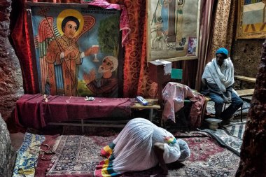 Lalibela, Etiyopya - 7 Ocak 2018: Lalibela 'da bir kilisede dua eden bir kadın. Ocak ayının ilk günlerinde binlerce Etiyopyalı Ortodoks Hıristiyan hacı Etiyopya 'daki Lalibela şehrine gider..