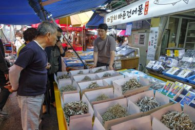 Busan, Güney Kore - 28 Mayıs 2023: Busan, Güney Kore 'deki Jagalchi pazarında kurutulmuş balık satan bir adam.