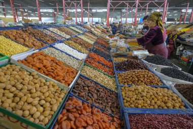 Bişkek, Kırgızistan - 2 Eylül 2023: Kırgızistan 'ın Bişkek kentindeki Osh Çarşısı' nda kurutulmuş meyve satan bir kadın.
