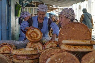 Celal-Abad, Kırgızistan - 4 Ekim 2023: Celal-Abad, Kırgızistan 'daki Merkez Çarşıda ekmek satan bir kadın.