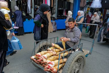 Osh, Kırgızistan - 6 Ekim 2023: Kırgızistan 'daki Jayma Çarşısı' nda inek bacağı satan bir adam.