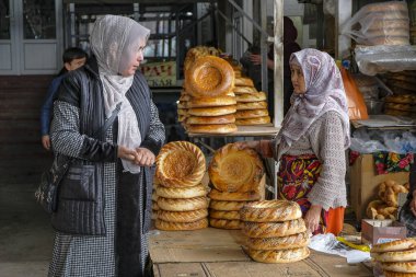 Osh, Kırgızistan - 8 Ekim 2023: Kırgızistan 'daki Jayma Çarşısı' nda ekmek satan bir kadın.