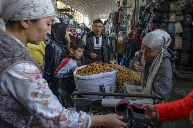 Osh, Kırgızistan - 8 Ekim 2023: Kırgızistan 'daki Jayma Çarşısı' nda fıstık satan bir kadın.