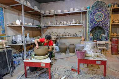 Rishton, Özbekistan - 22 Ekim 2023: Özbekistan 'ın Rishton kentindeki çömlek atölyesinde çalışan bir adam.