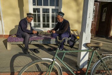 Istaravshan, Tajikistan - November 26, 2023: Two men playing cards in Istaravshan, Tajikistan. clipart