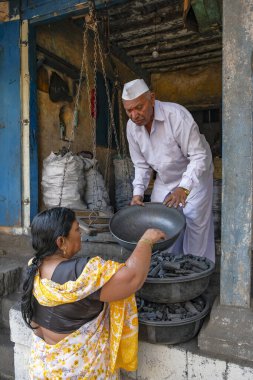 Nashik, Hindistan - 26 Ocak 2024: Nashik, Hindistan 'da Ganga Ghat' ta kömür satan bir adam.