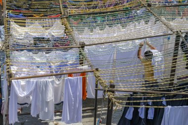 Mumbai, Hindistan - 3 Mart 2024: Mahalaxmi Dhobi Ghat 'ta çalışan bir adam, Mumbai, Hindistan' daki en büyük açık hava çamaşırhanesi..