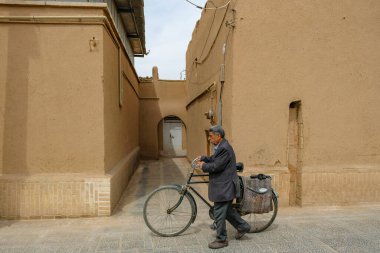 Yazd, İran - 24 Mart 2024: İran 'ın Yazd kentinde bisiklet süren bir adam.