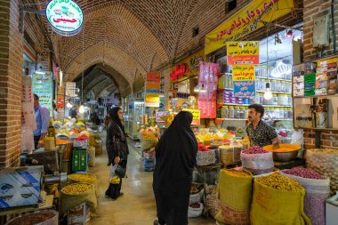 Urmia, Iran - April 20, 2024: Women buying spices in the Urmia Historical Bazaar, Iran. clipart