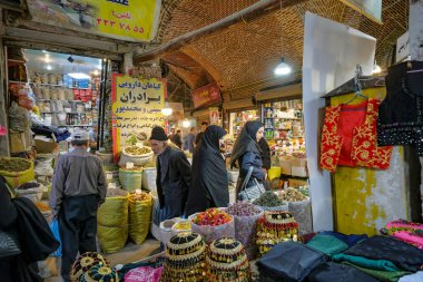 Urmia, Iran - April 20, 2024: People buying dried fruits in the Urmia Historical Bazaar, Iran. clipart