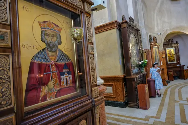 stock image Tbilisi, Georgia - June 5, 2024: A woman reading inside the Holy Trinity Cathedral of Tbilisi in Georgia.