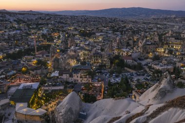 Goreme, Türkiye - 14 Ağustos 2024: Günbatımında Goreme köyü manzarası, Kapadokya, Türkiye.