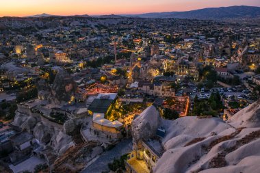 Goreme, Türkiye - 14 Ağustos 2024: Günbatımında Goreme köyü manzarası, Kapadokya, Türkiye.