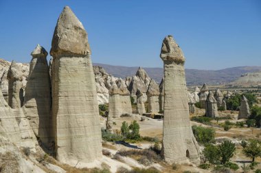 Goreme, Türkiye - 15 Ağustos 2024: Kapadokya 'daki Aşk Vadisi' nde Eşsiz jeolojik oluşumlar.