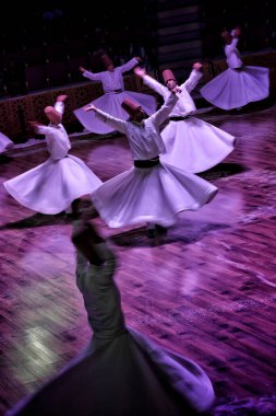 Konya, Türkiye - 18 Ağustos 2024: Türkiye 'nin Konya kentinde düzenlenen sufi dönen bir gösteri sırasında dönen dervişler.