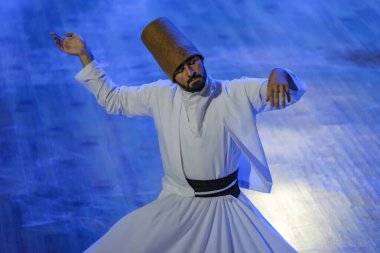 Konya, Türkiye - 18 Ağustos 2024: Türkiye 'nin Konya kentinde düzenlenen sufi dönen bir gösteri sırasında dönen dervişler.