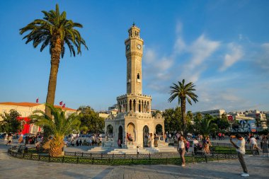 İzmir, Türkiye - 1 Eylül 2024: İzmir 'in Konak Meydanı' ndaki tarihi Saat Kulesi 'nin yanında yürüyen insanlar.