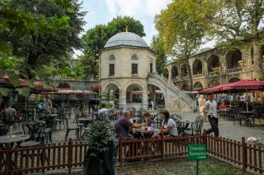 Bursa, Türkiye - 7 Eylül 2024: Koza Han çay bahçeleri ve Koza Han İpek Çarşısı 'ndaki cami. Koza Han, Bursa, Türkiye 'nin Osmanlı döneminden kalma tarihi bir yerdir..