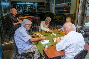 İstanbul, Türkiye - 18 Eylül 2024: İstanbul, Türkiye 'deki Kadıköy pazarında Okey, Rummikub oynayan bir grup erkek.