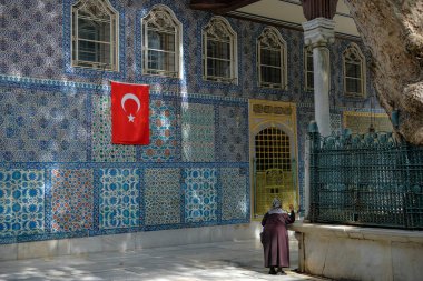 İstanbul, Türkiye - 23 Eylül 2024: Eyüp Sultan Camii 'ni ve Ebu Eyyub el Ansari' nin İstanbul 'daki türbesini ziyaret eden bir kadın.