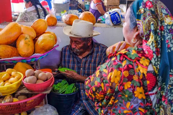Tlacolula de Matamoros, Meksika - 2 Mart 2025: Tlacolula de Matamoros, Meksika 'daki pazar pazarında meyve satan bir adam.