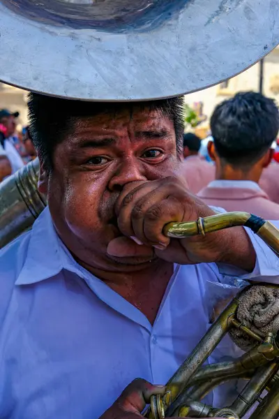 Oaxaca de Juarez, Meksika - 3 Mart 2025 Oaxaca de Juarez, Meksika 'da Yalnızlık Anıtımızın Bazilikası' nın yanında korna çalan bir müzisyen.