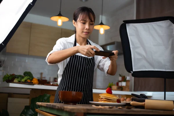 写真家の食べ物アジアの女性はスタジオで食べ物の写真を撮っています ロイヤリティフリーのストック画像