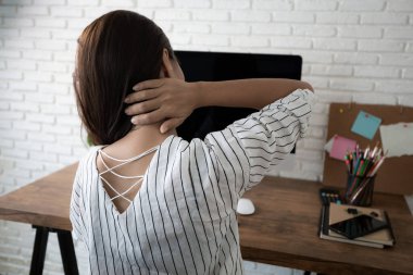 İş kadını iş yerinde çalışırken boynu ağrıyormuş.