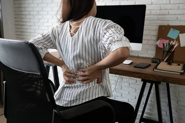 事務所の家で腰痛に苦しむビジネス女性 ロイヤリティフリーのストック写真