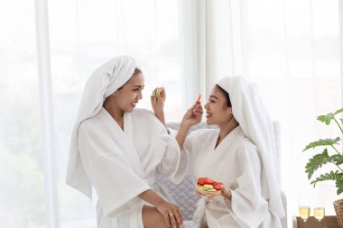 Asyalı bayan arkadaşlar rahatlar ve domates maskeli ve bornozlu spa masajı yaparlar. Spa, güzellik, sağlık masajı. , Tayland aromaterapi spa tedavileri kadınlar için, vücut