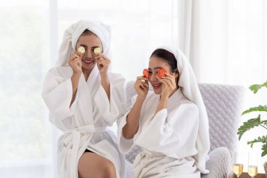 Asyalı bayan arkadaşlar rahatlar ve domates maskeli ve bornozlu spa masajı yaparlar. Spa, güzellik, sağlık masajı. , Tayland aromaterapi spa tedavileri kadınlar için, vücut