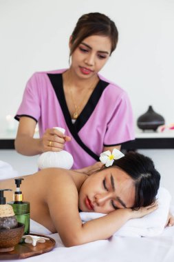 Taylandlı kadın masaj terapisti, bir müşteriye masaj yaparken masaj yapıyor.