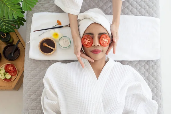 温泉サロンでトマトで目の自然治療を受けるリラックスした若いアジア人女性 健康と癒しの概念 — ストック写真