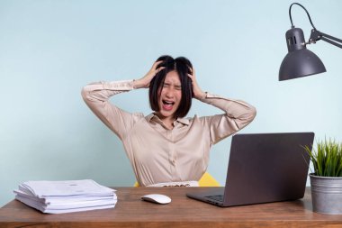 Dizüstü bilgisayarı olan yorgun, bitkin, Asyalı bir kadın, projeyle ilgili problemler, depresyonda, ofiste tembellik