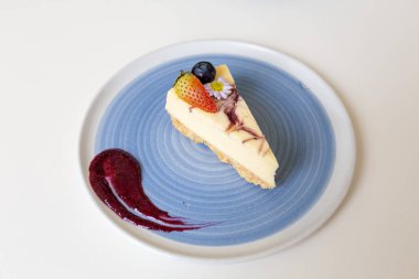 Kafedeki bir masada tabakta bir dilim peynirli keki yakından çek..