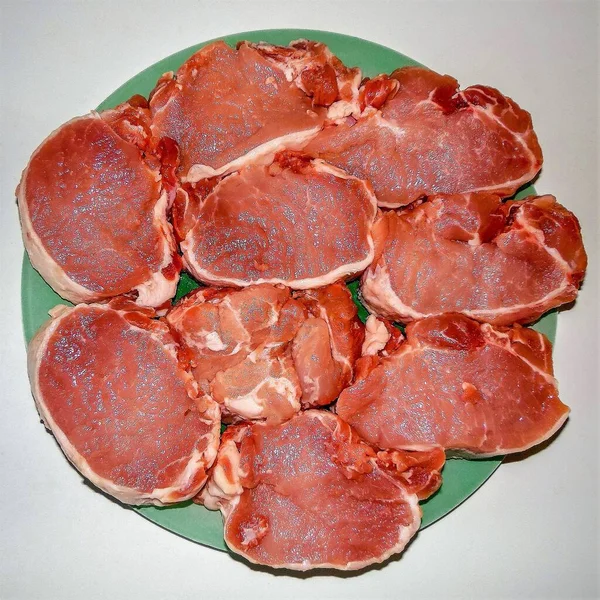 Carne Maiale Fresca Tagliata Porzioni Tritare Piatto Verde Uno Sfondo — Foto Stock