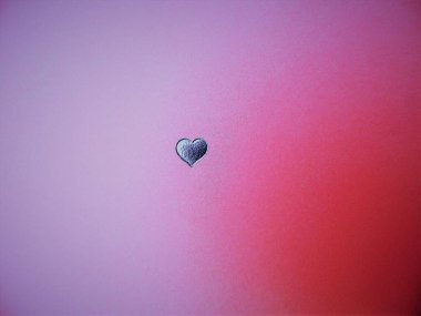 texture of pink cardboard with an embossed silver heart