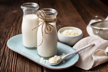 Kefir, sağIıklı probiyotik içecek. Tahta arka planda süt tanecikleri var.